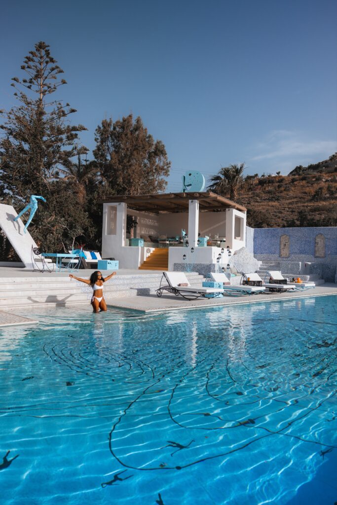 Woman in bikini stands in sea front pool at Agalia Resort in Ios, Greece