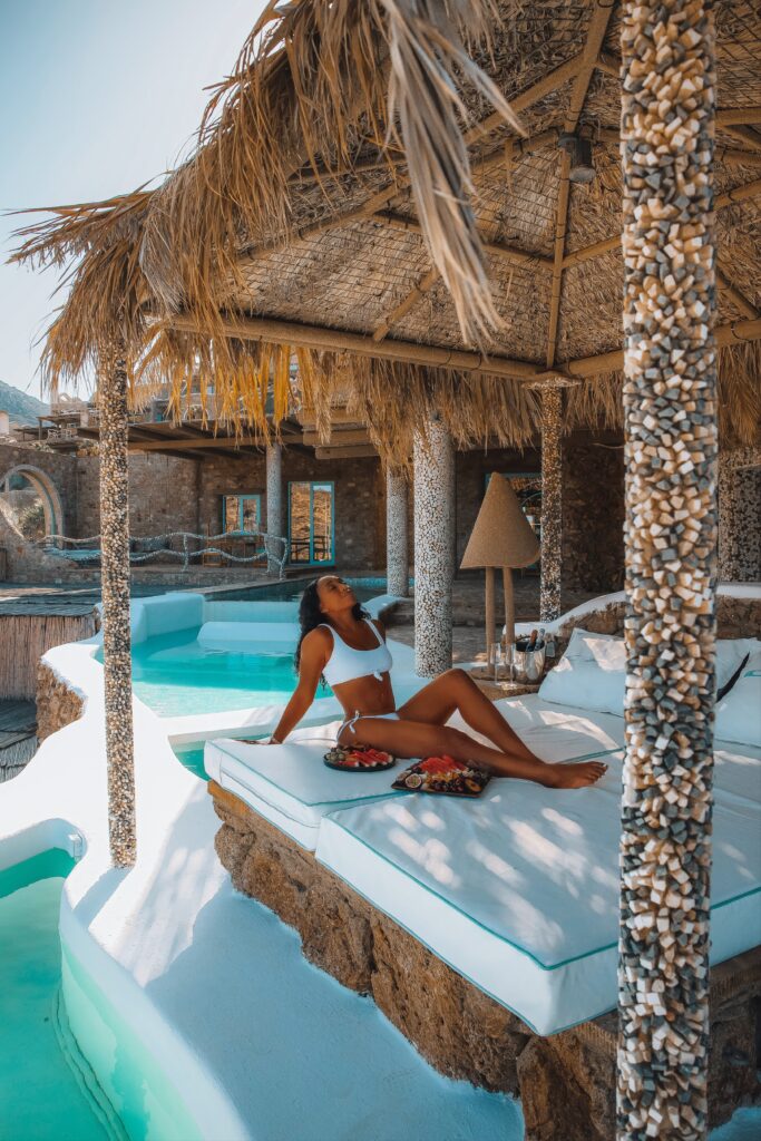 Woman in white bikini sunbathes at the Ray of Light Suite at the Calilo Resort in Ios, Greece