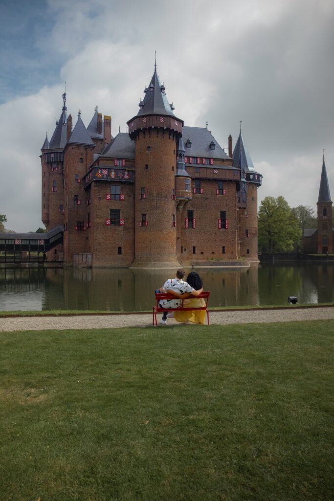 Couple sit on a bench by Castle De Haar Pond in Amsterdam