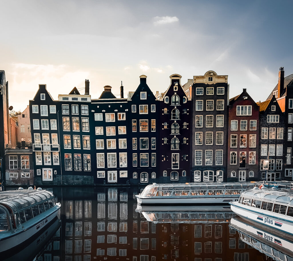 View of river-side buildings and boats in the river in Amsterdam