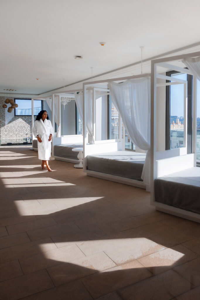 Woman in white robe walks along a spa lounge