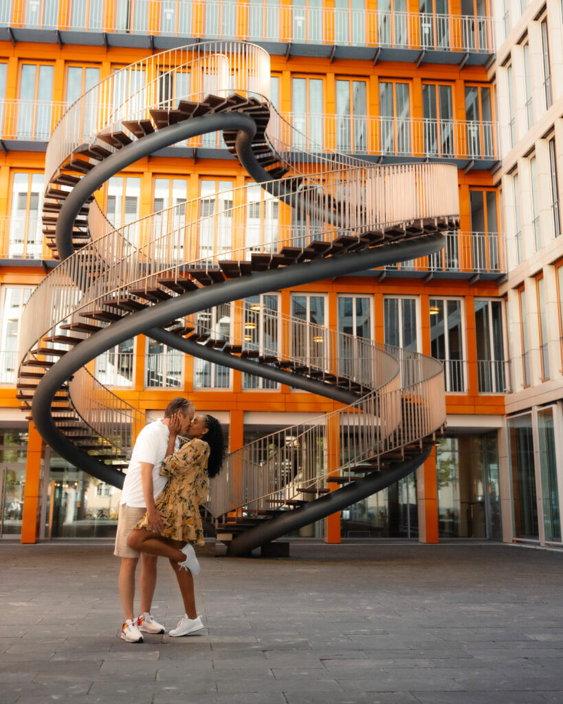 Couple kisses in front of the Endless Stairs in Munich