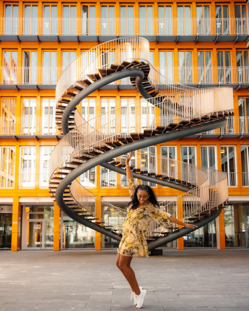 Woman dances in front of the Endless Stairs in Munich