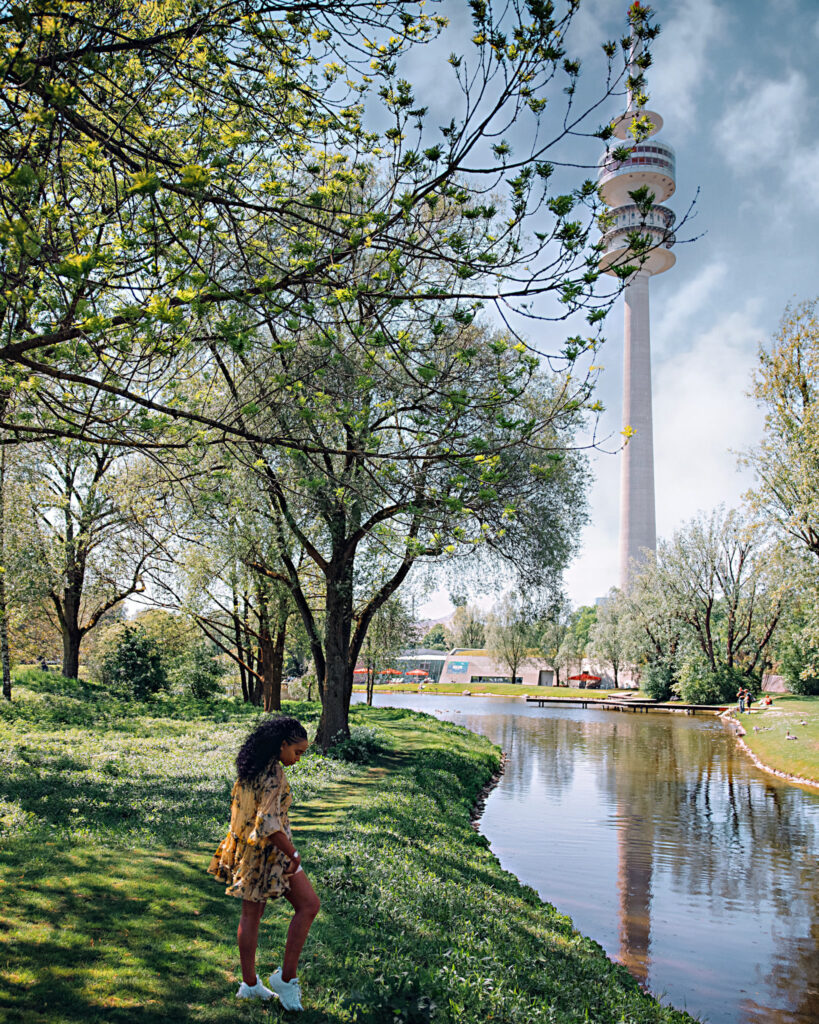 Woman walks along the river by Olympic Park in Munich