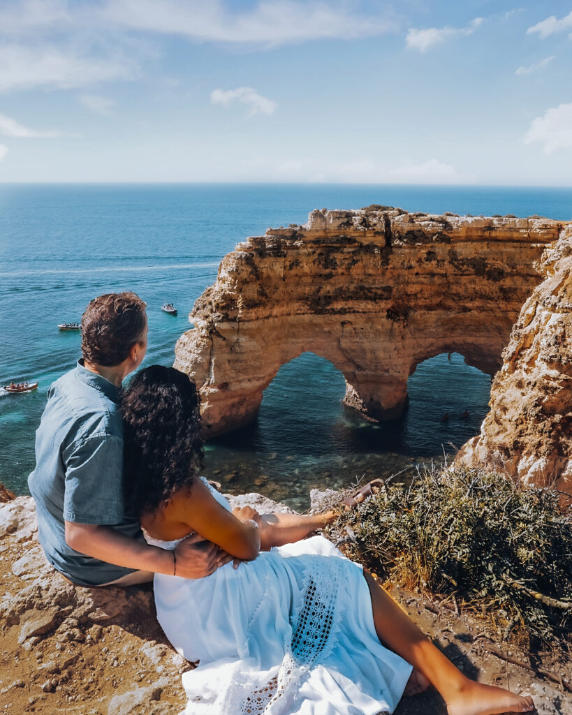 Brett & Zee sits on the cliffside at Praia da Marinha