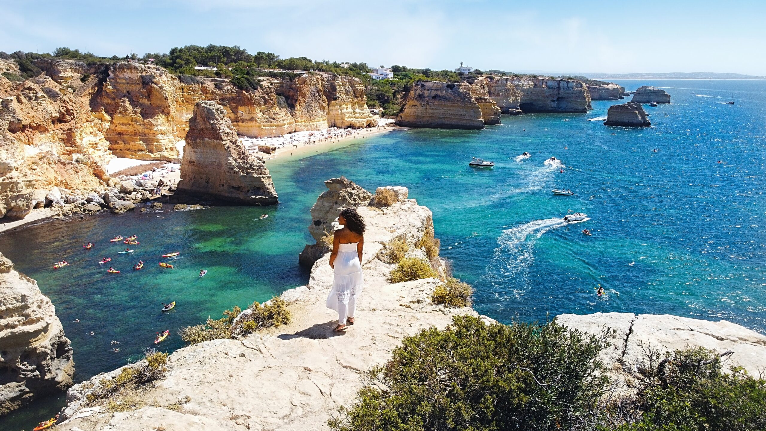 Zee stands on Cathedral Rock overlooking Praia da Marinha Beach