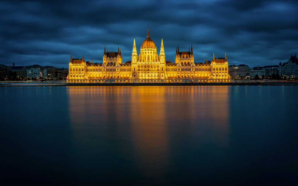 Hungarian Parliament lit up at night on the Danube River in Budapest at Christmas