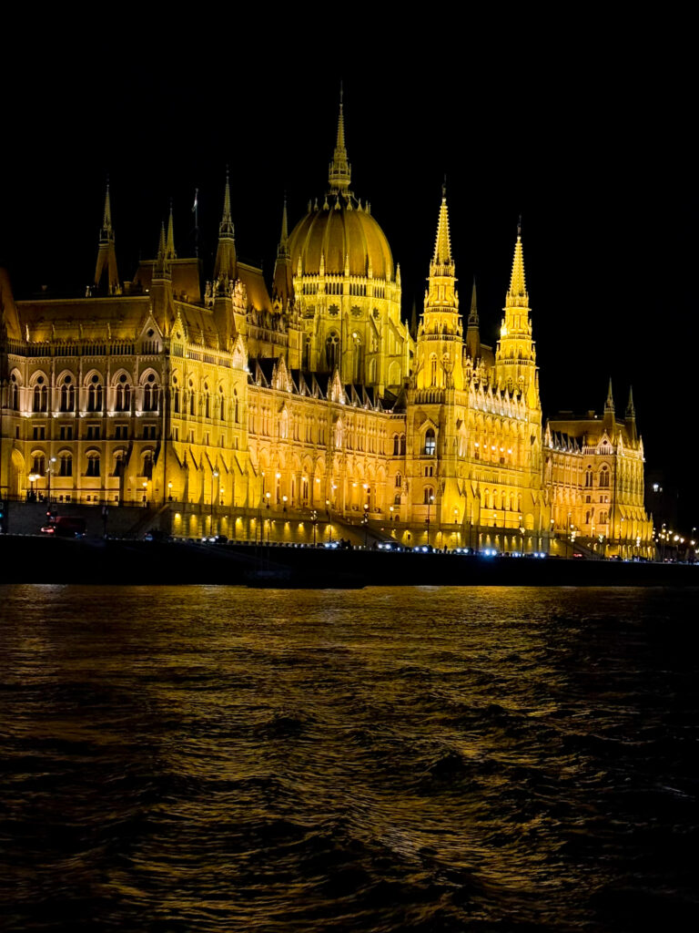 Hungarian Parliament Building illuminated at night viewed from the Duna River Cruise in Budapest at Christmas.