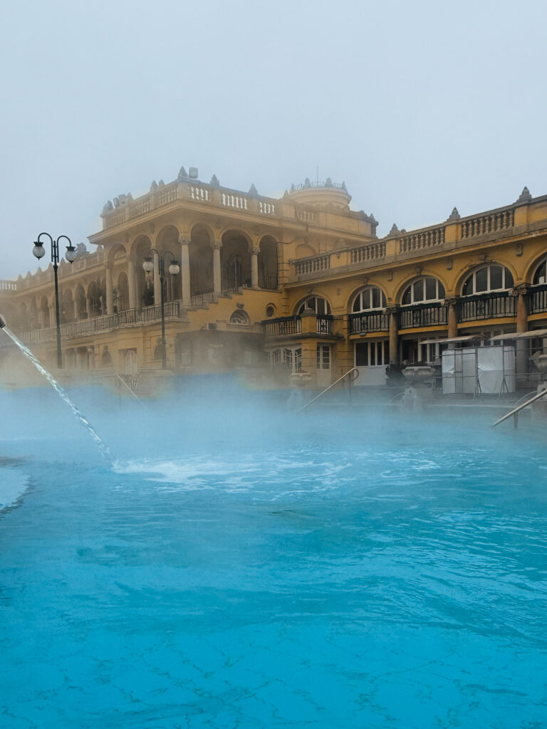 Széchenyi Thermal Bath exterior with steaming pools and neo-baroque architecture in Budapest is a must visit during the holiday season.